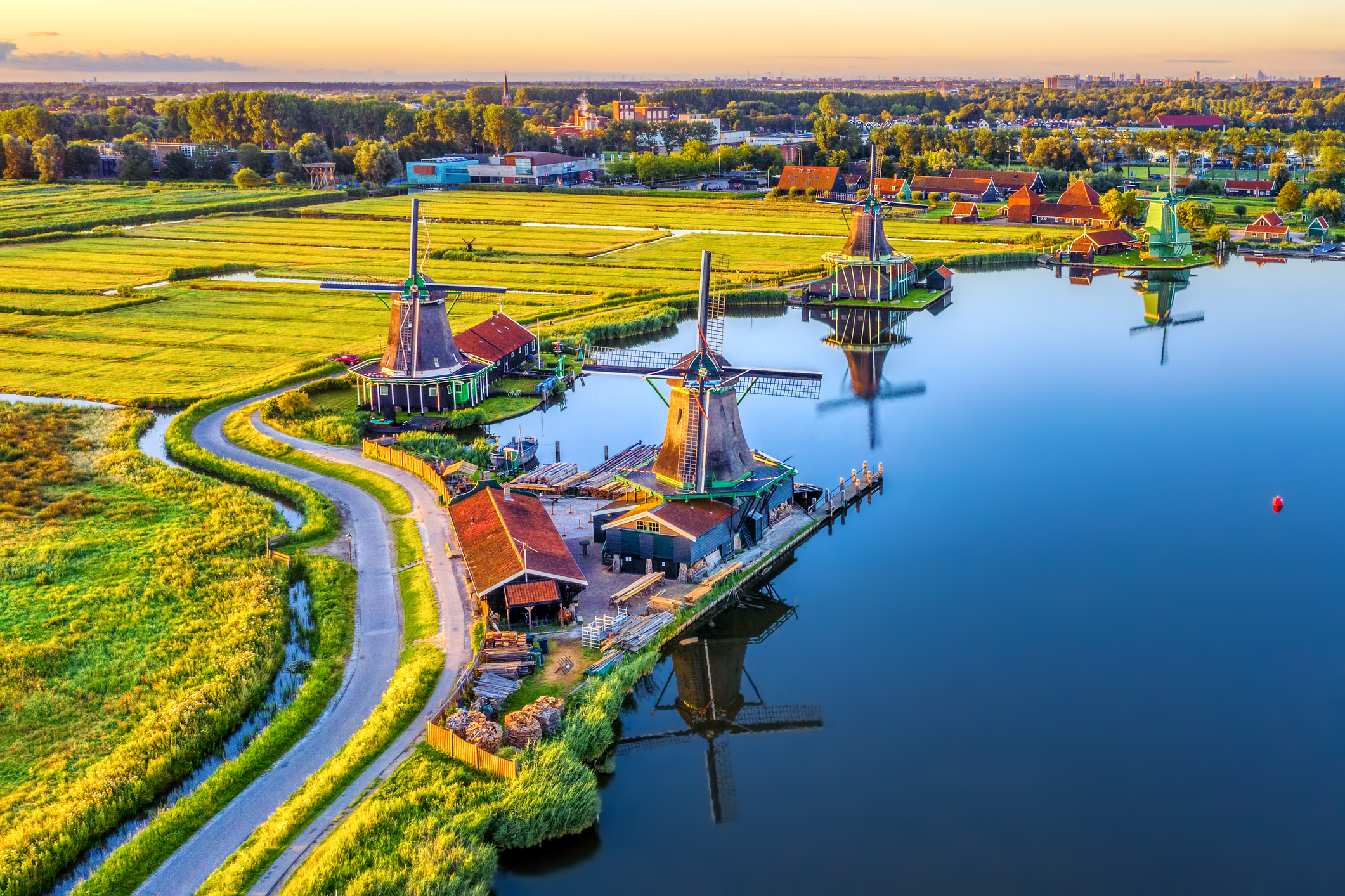 Aerial view of historic windmills along the river at Zaanse Schans at sunrise